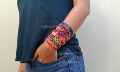 a person wearing a colorful bracelet and jeans