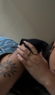 a woman with tattoos on her arm laying down