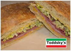 two sandwiches cut in half sitting on top of a white tablecloth with the words toddsky's next to it