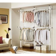 an open closet with clothes hanging on the wall and drawers below it, in front of a white rug