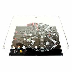 a star wars millennium falcon model in a glass display case with lego minifigurs