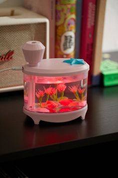 an electric fish tank with red flowers inside