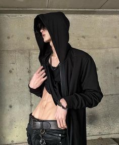 a man with no shirt wearing a black hoodie and holding his hand on his hip