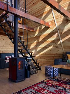 a living room filled with furniture and a fire place in the middle of a wooden floor