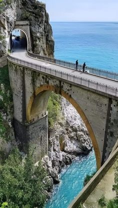 people are standing on the side of a bridge