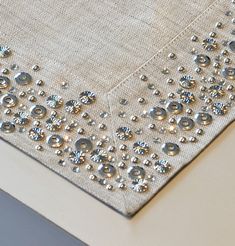 a piece of cloth with silver beads on it