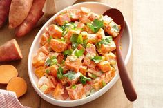 a white bowl filled with food next to sliced carrots