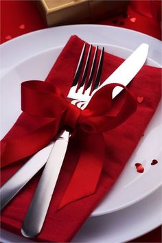 silverware and red napkins on a white plate