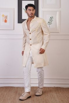 Cream long sherwani with gold buttons, elevated with tonal and placement floral embroidery. Paired with a pant. - Aza Fashions Elegant Long Sleeve Sherwani With Gota Work, Designer Gota Work Kurta For Eid, Elegant Bandhgala With Gota Work For Designer Wear, Elegant Bandhgala With Gota Work For Diwali, Bandhgala With Gota Work For Diwali Reception, Elegant Bandhgala With Gota Work, Elegant Ceremonial Bandhgala With Gota Work, Diwali Reception Bandhgala With Gota Work, Ceremonial Sherwani With Gota Work And Long Sleeves