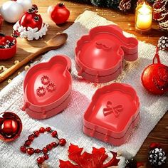 three heart shaped cake pans sitting on top of a towel next to christmas decorations