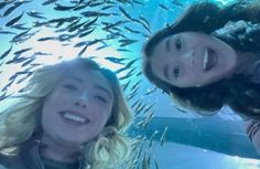 two young women are smiling under the water