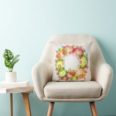 a chair with a pillow on it next to a potted plant and a table