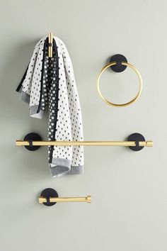 a towel rack with two hooks and a scarf hanging on the wall next to it