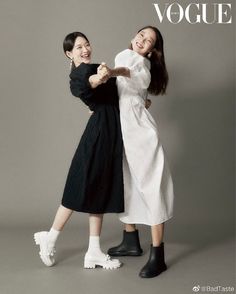 two women in black and white dresses standing next to each other with their arms around one another