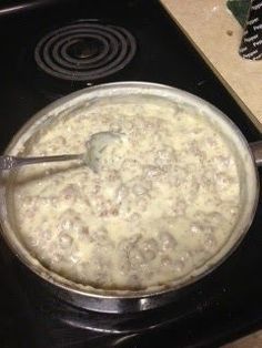 a pot on the stove is full of food and has a ladle in it