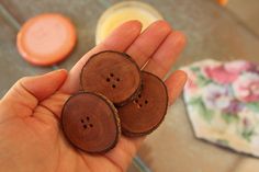 three wooden buttons in the palm of someone's hand