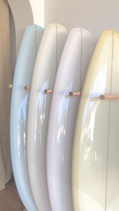 four surfboards are lined up against the wall