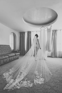 a woman standing in front of a couch wearing a veil