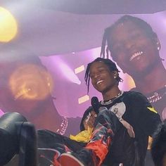 a man with dreadlocks sitting in front of a microphone and smiling at the camera