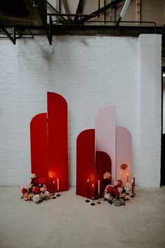 three red and white mirrors sitting next to each other in front of a brick wall