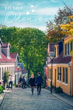 people walking down a cobblestone street in old town