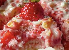 a close up of a piece of cake with strawberries on top and icing