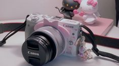 a camera with a hello kitty keychain attached to it's front and side