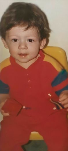 a young boy sitting in a yellow chair