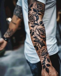 a man's arm with roses and leaves on it