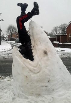 a man is sitting on top of a snowman