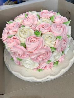 a white and pink cake sitting on top of a table next to a cardboard box