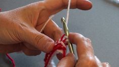 two hands are knitting together with yarn