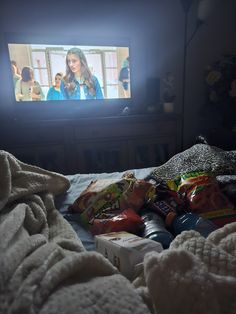 a tv that is on in the dark with food all over it and people standing around