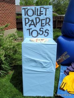 an inflatable toilet sitting next to a sign that says toilet paper toss