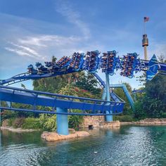 the roller coaster at six flags amusement park is blue and has several people on it