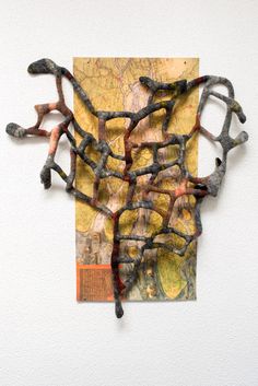 a piece of art that has been made to look like branches on a map and is hanging on the wall