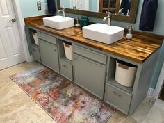 a bathroom with two sinks and a rug on the floor