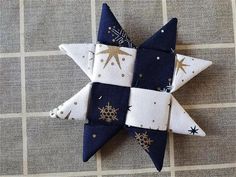 an ornament made out of fabric with snowflakes and stars on it