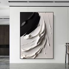 an abstract painting hangs on the wall next to a dining room table with chairs in it