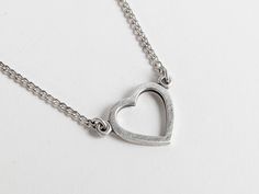 Infuse a dash of 90s charm into your accessory collection with this vintage heart pendant necklace. Beautifully crafted from silver (stamped on the back), this lovely piece features an openwork filigree heart outline hanging gracefully from a curb chain and fastens with a non-original, over-sized silver tone spring ring. Its minimalist design is ideal for adding a subtle statement to any outfit. This delightful necklace would serve as a heartfelt token of affection, making it a splendid love gif Metal Open Heart Charm Necklace, Everyday Metal Heart Pendant Charm Necklace, Everyday Metal Charm Necklace With Heart Pendant, Minimalist Metal Heart Necklace For Everyday, Dainty Metal Heart Necklace For Everyday, Everyday Metal Open Heart Necklace, Everyday Open Heart Metal Necklace, Minimalist Heart-shaped Metal Charm Necklace, Everyday Metal Heart Necklace For Valentine's Day