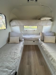 the inside of a camper with two beds and pillows