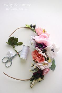 flowers and thread laid out on a white surface