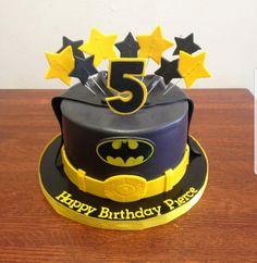 a batman themed birthday cake with five stars and the number 5 on it's top