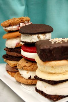 a white plate topped with lots of ice cream sandwiches next to cookies and oreos