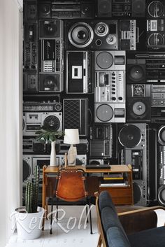 a living room filled with furniture and wallpaper covered in boomboxes on the walls