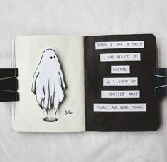 an open notebook with a drawing of a ghost on the front and back pages in black and white