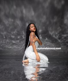 a woman sitting on top of a body of water