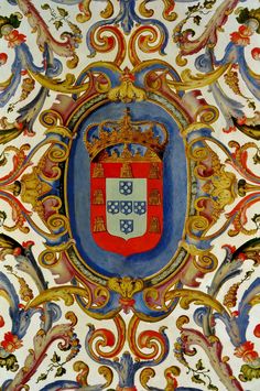 an ornately painted wall with a red, white and blue coat of arms on it