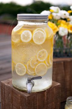 a mason jar filled with lemonade sitting on top of a wooden block