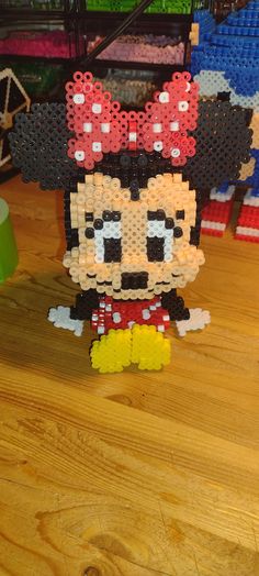 a mickey mouse made out of legos on top of a wooden table next to other toys